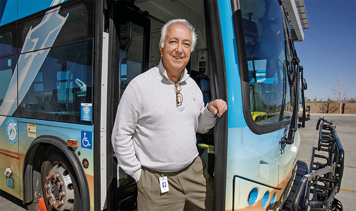 Macy Neshati standing at the front doors of an AVTA bus.