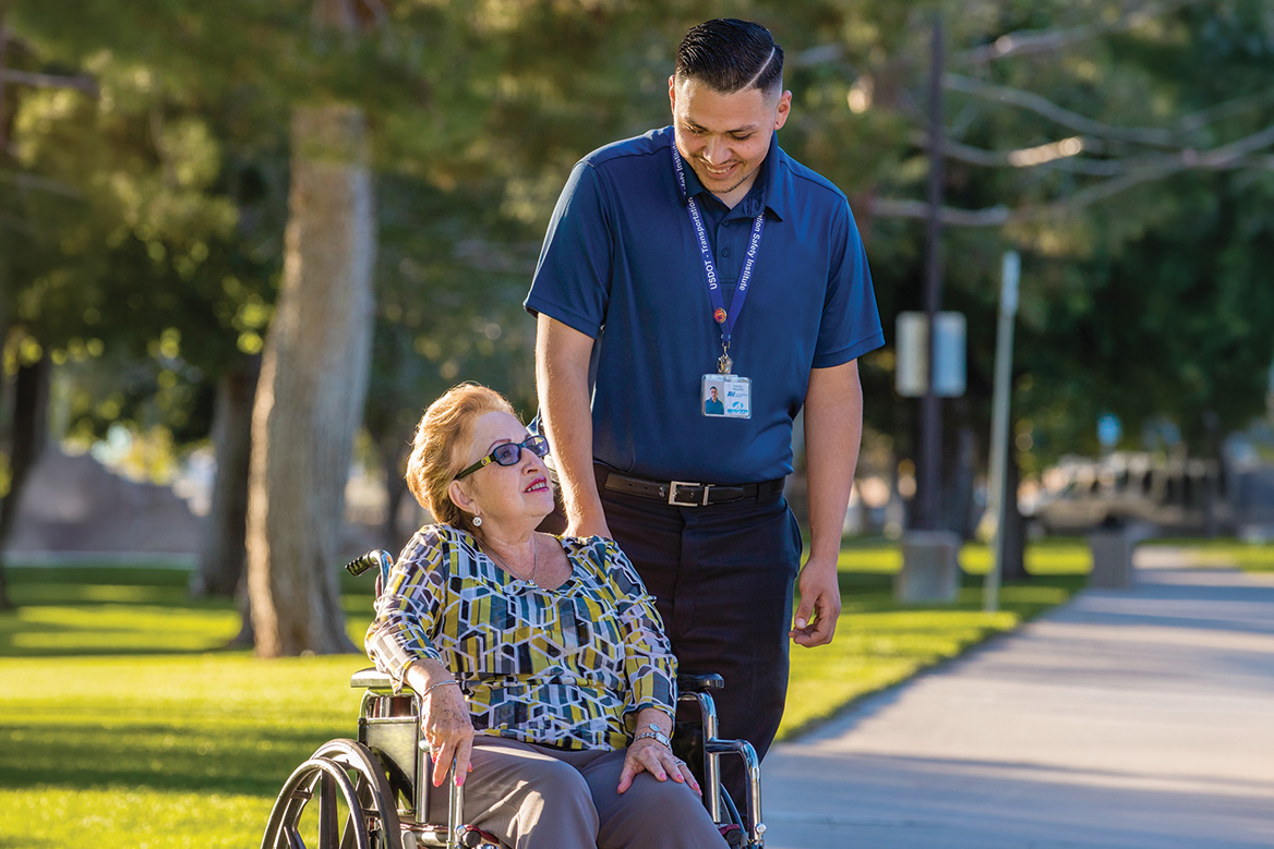 An AVTA customer service representative helping a patron with a wheelchair.