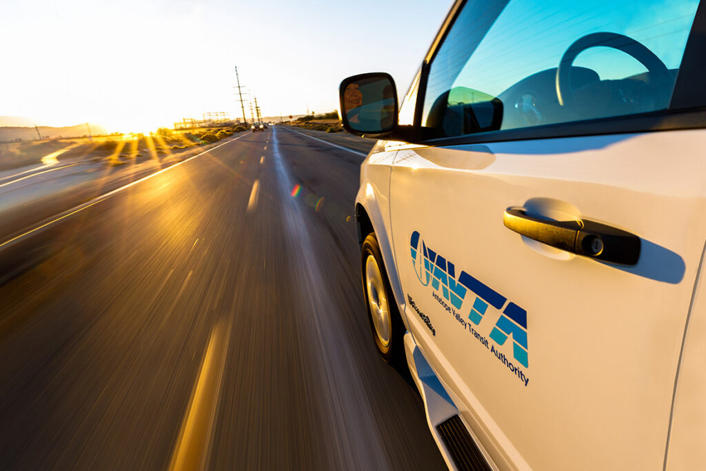 Side view of an AVTA Vehicle driving on a road.