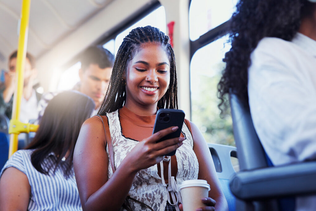 Female patron reading her cell phone while on the bus.