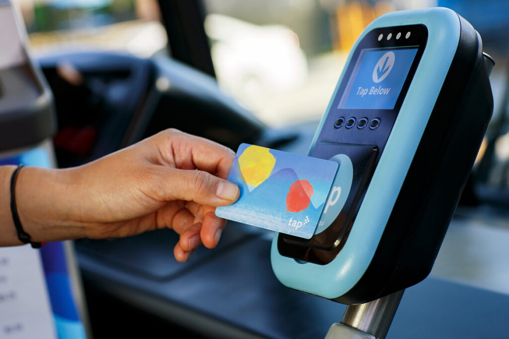 A patron using their tap card for entry onto the bus.