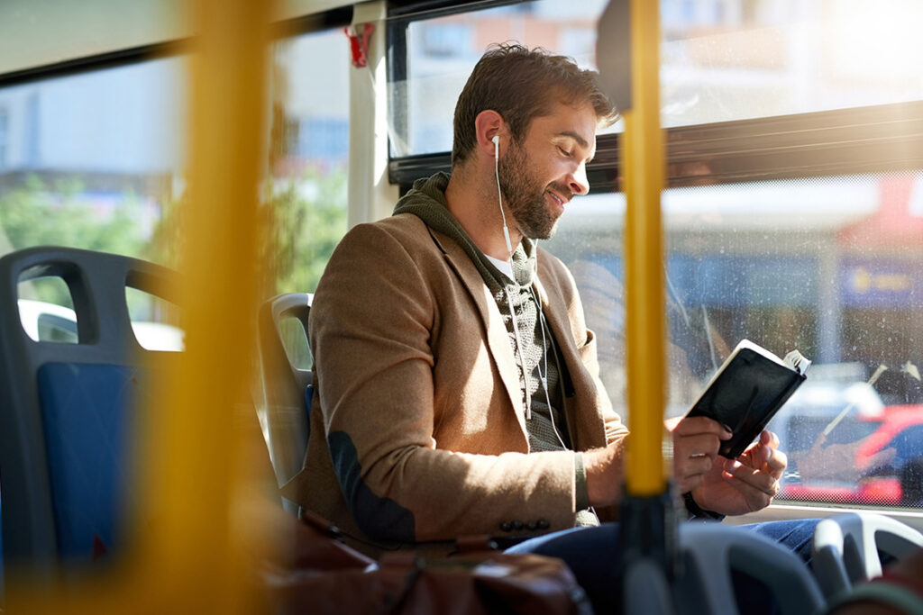 A Patron with headphones in reading a book.
